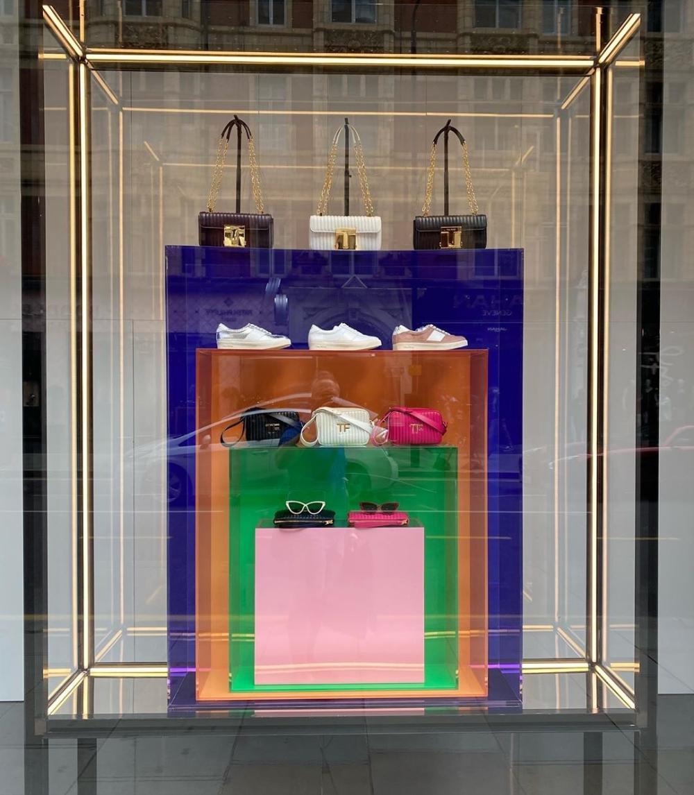 Colored suede shoes stand on display in the window of a retail